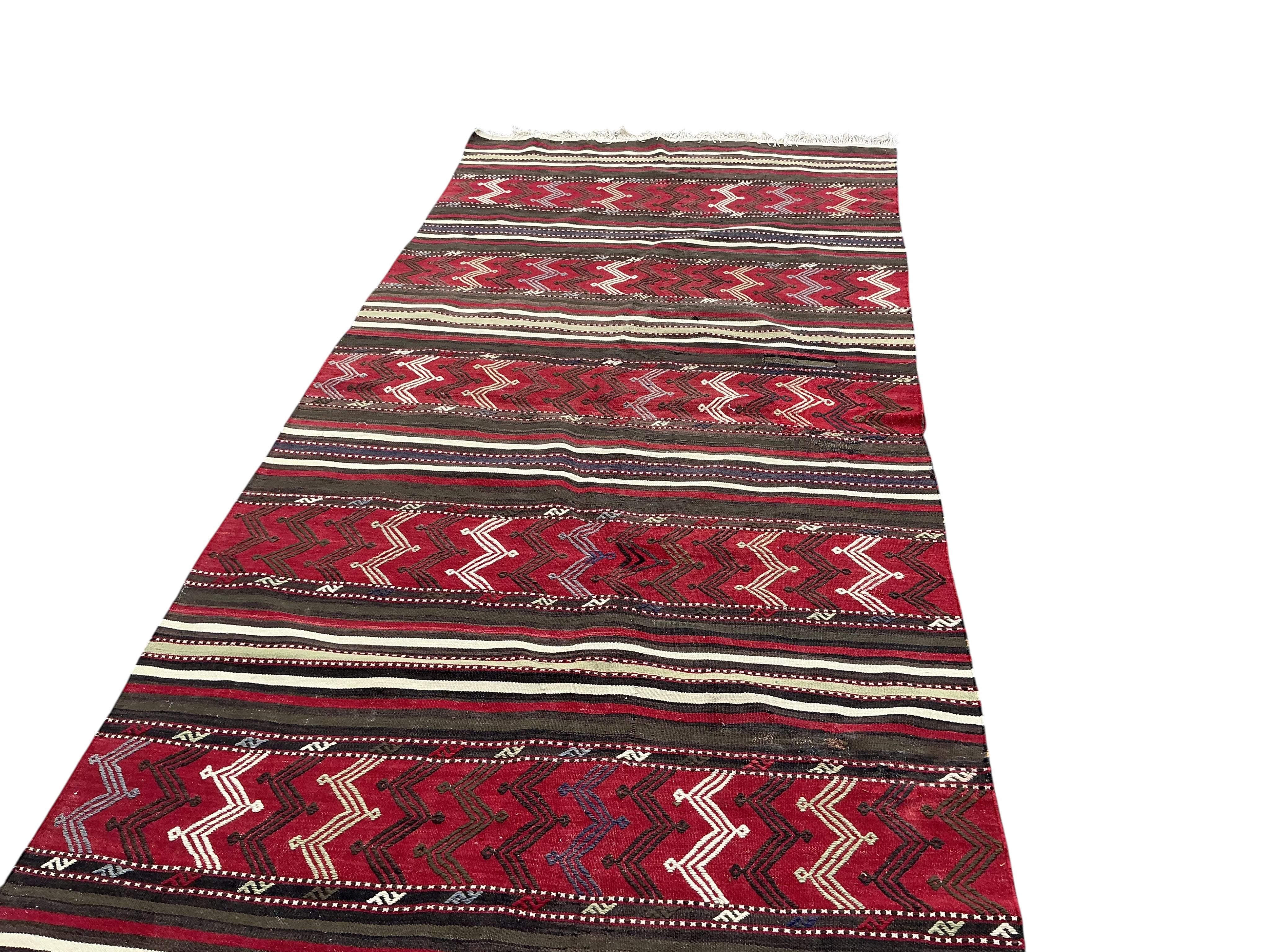 A Turkish kilim flat weave hall carpet, 320 x 140cm